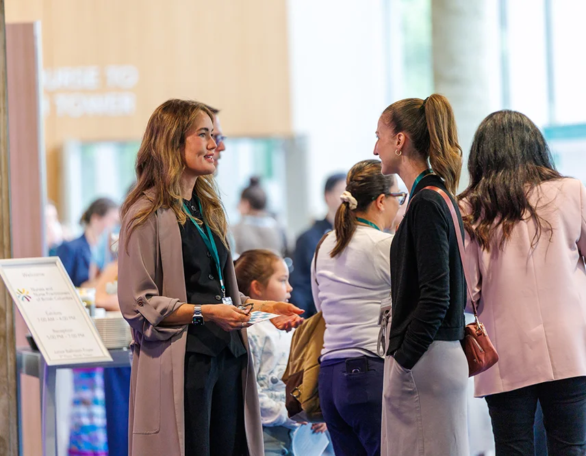 Two female nurse practitioners chatting during a nursing conference.